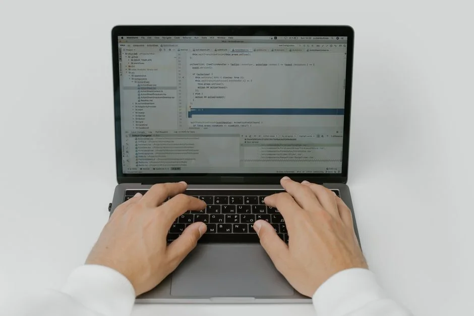 A close-up view of a laptop with a website open, placed on a wooden table near a window.